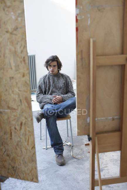 Jovem sentado no estúdio de arte — Fotografia de Stock