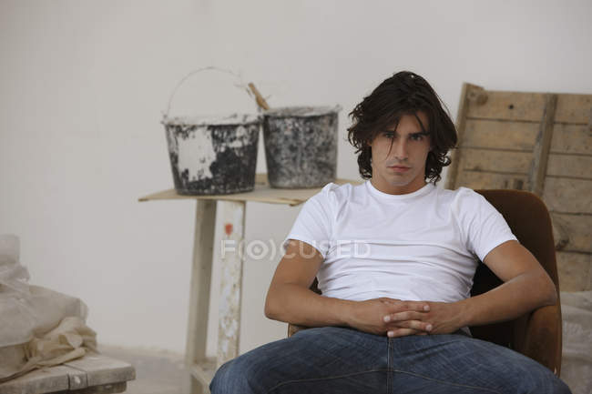 Молодий чоловік сидить у художній студії — стокове фото