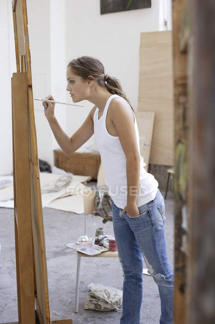 Молодая женщина работает над картиной — стоковое фото