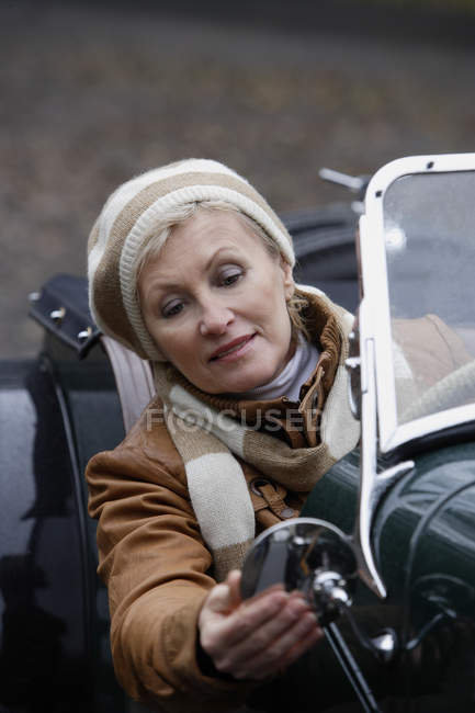 Mujer mayor conduciendo coche antiguo - foto de stock