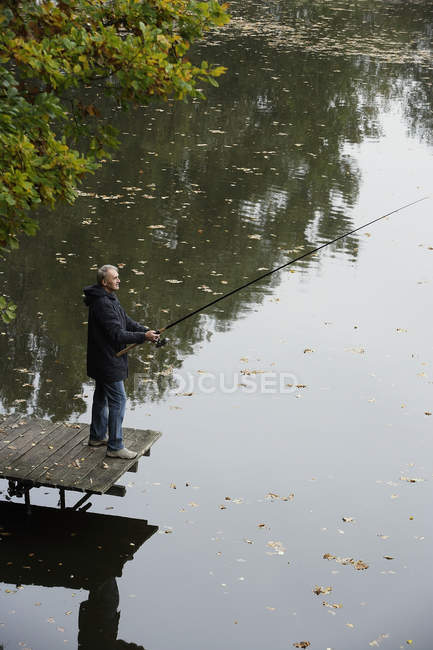 Людина риболовля на озері — стокове фото