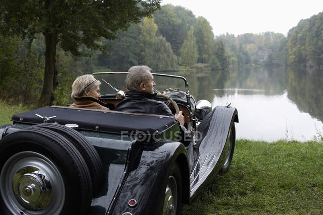 Coppia anziana guida in auto d'epoca — Foto stock