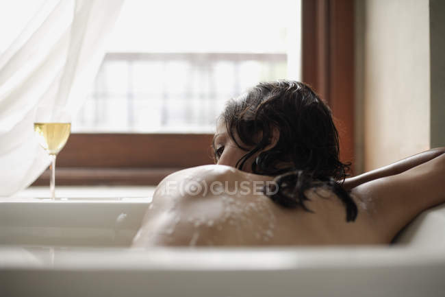 Mujer tendida en la bañera - foto de stock