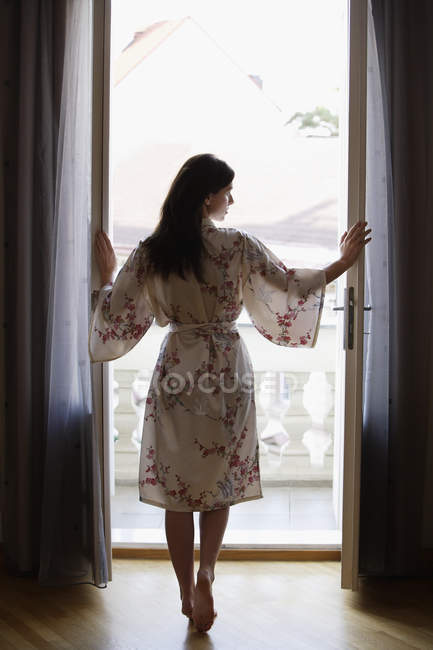 Mujer de pie en la puerta - foto de stock