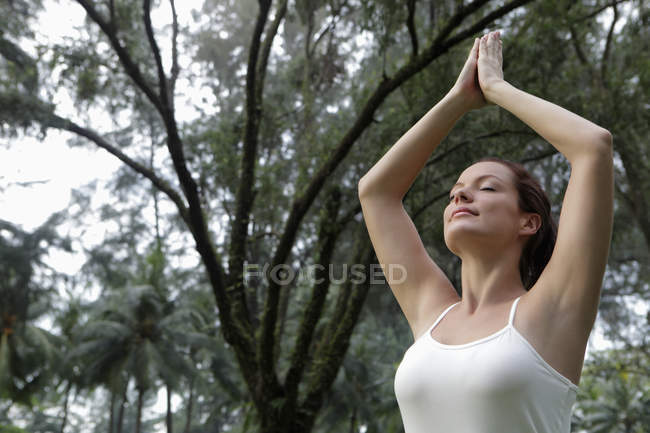 Жінка робить вправи йоги під деревами — стокове фото