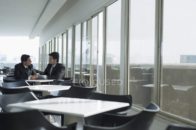Colleagues sitting in cafeteria and having conversation — Stock Photo