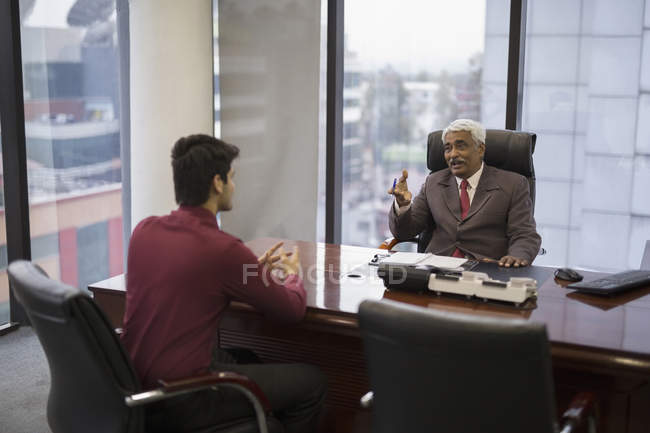 Uomo d'affari parlando con l'uomo più giovane — Foto stock