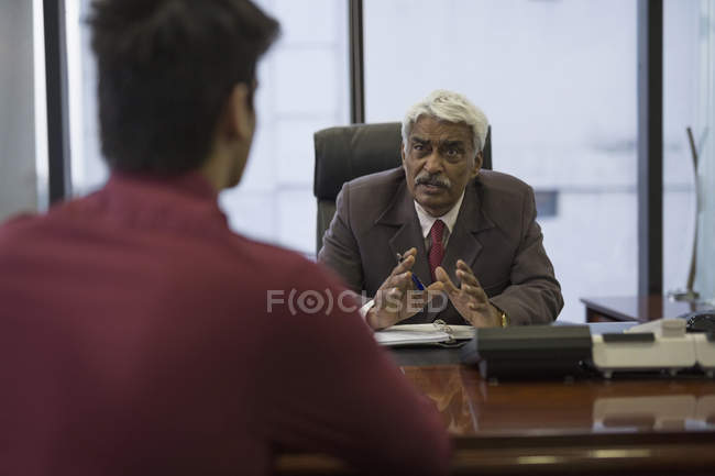 Businessman talking with younger man — Stock Photo