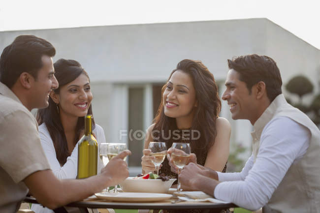 Friends drinking wine at table — Stock Photo