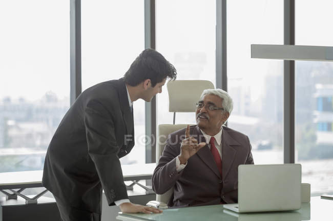 Hombre de negocios hablando con el hombre más joven - foto de stock