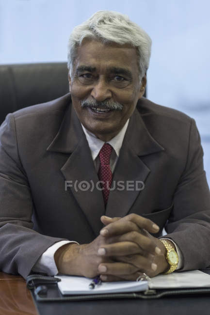 Businessman sitting with hands folded — Stock Photo