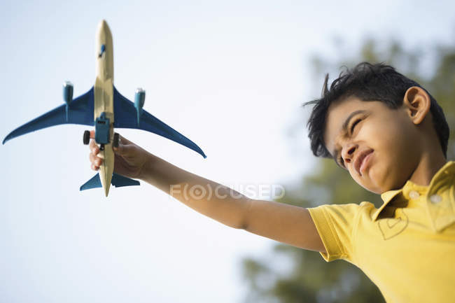 Chico jugando con juguete avión - foto de stock