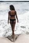 Junge Frau steht am Strand — Stockfoto