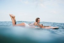 Frau liegt auf Surfbrett — Stockfoto