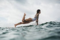 Frau posiert auf Surfbrett — Stockfoto
