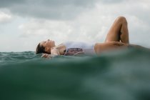 Woman laying on surf board — Stock Photo