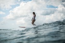 Female surfer catching wave — Stock Photo