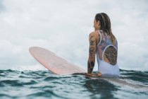 Donna seduta a tavola da surf — Foto stock
