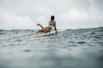 Femme debout en pose sur la planche de surf — Photo de stock