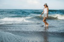 Femme souriante marchant sur la plage — Photo de stock
