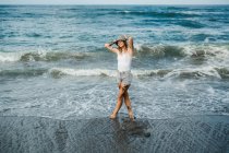 Улыбающаяся женщина, гуляющая по пляжу — стоковое фото