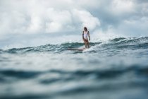 Femelle surfeur attraper vague — Photo de stock