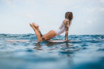 Woman standing in pose on surf board — Stock Photo