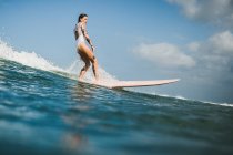Female surfer catching wave — Stock Photo