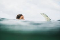 Woman in sea water with surf board — Stock Photo