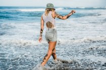 Femme marchant sur la plage — Photo de stock
