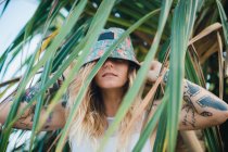 Femme dans les buissons verts regardant la caméra — Photo de stock