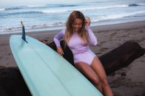 Surfeur assis avec planche de surf sur la plage — Photo de stock