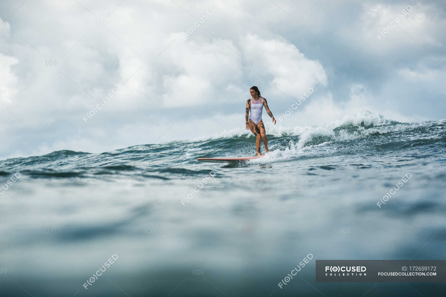 Female surfer catching wave — fit, portrait - Stock Photo | #172659172