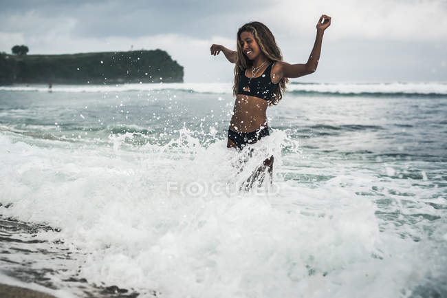 Jovem mulher se divertindo na praia — Fotografia de Stock