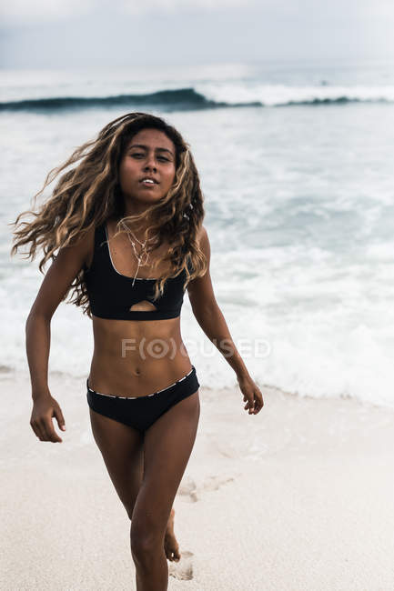 Jovem menina bonita andando na praia — Fotografia de Stock