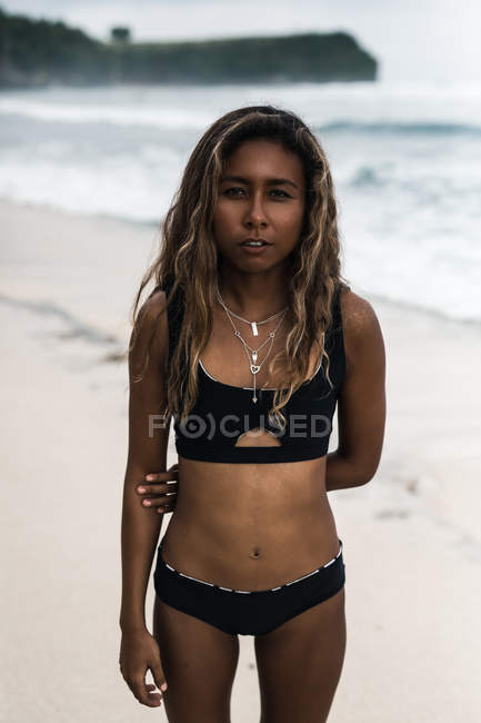 Atractiva joven de pie en la playa - foto de stock