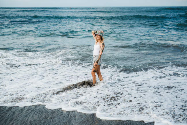 Frau geht am Strand spazieren — Stockfoto