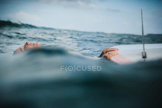 Woman holding surf board in water — Stock Photo