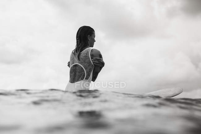 Donna seduta a tavola da surf — Foto stock