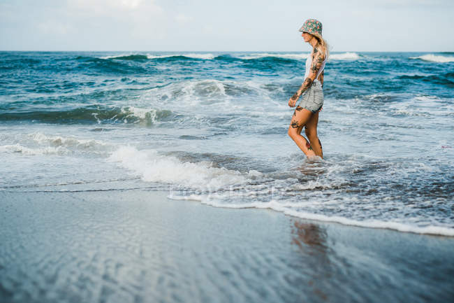 Donna che cammina sulla spiaggia — Foto stock