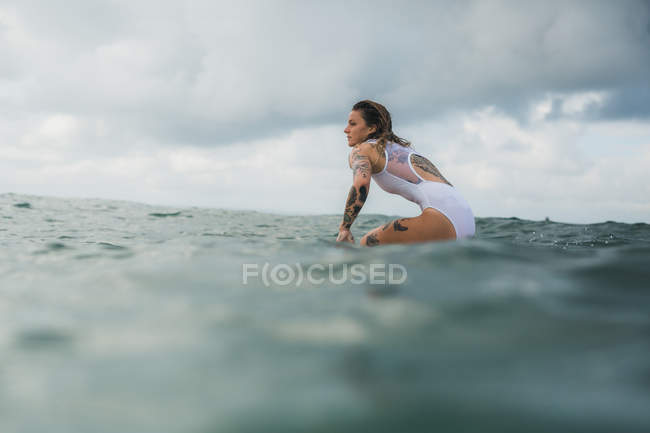 Mulher sentada no surf board — Fotografia de Stock