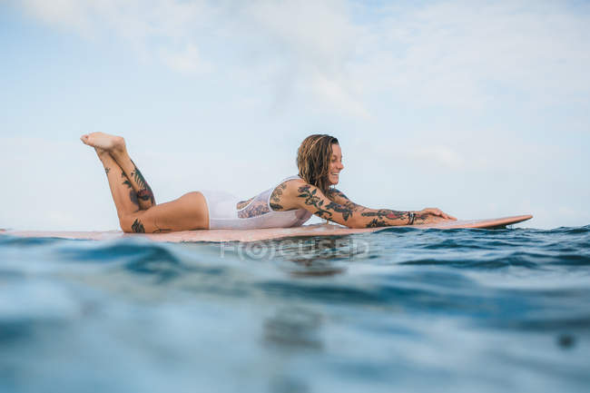 Жінка лежить на дошці для серфінгу — стокове фото