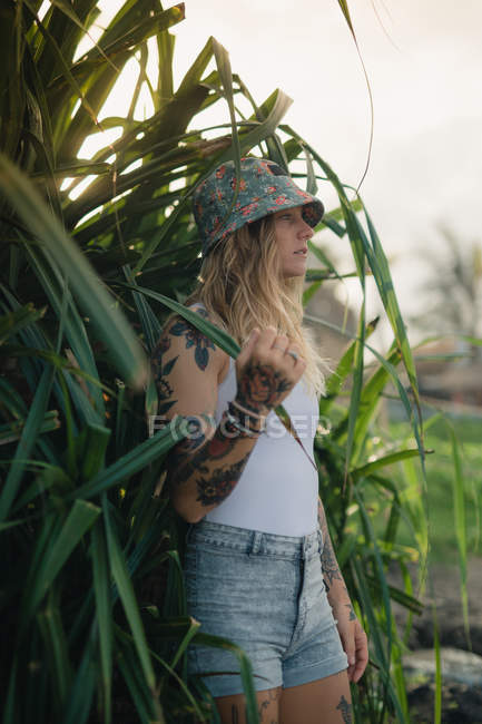 Woman in green bushes looking aside — Stock Photo