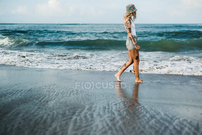Mujer caminando en la playa - foto de stock