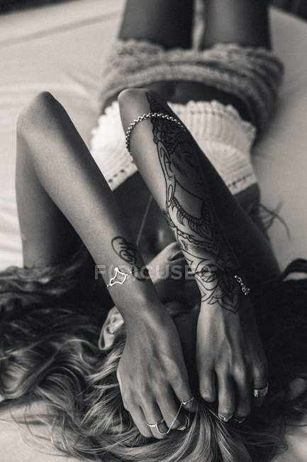 Femme couchée sur le lit avec les mains dans les cheveux — Photo de stock