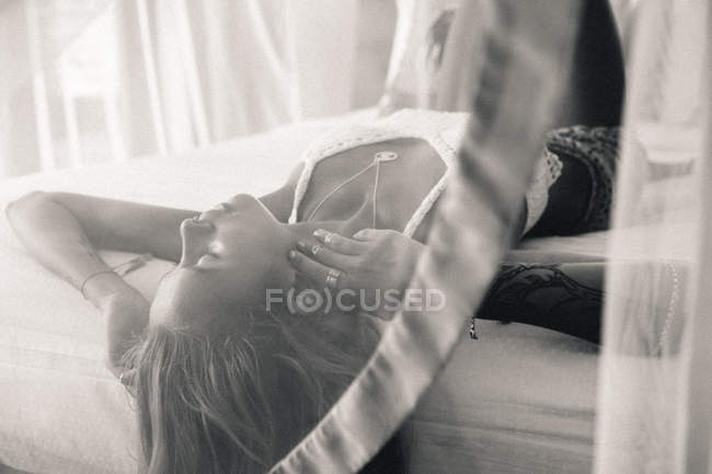 Porträt einer Frau, die auf dem Bett liegt — Stockfoto