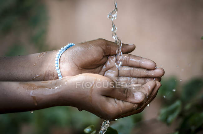 Hände nehmen Wasser aus dem Wasserhahn — Stockfoto