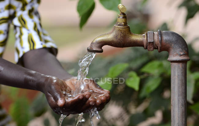 Hände eines afrikanischen Kindes voller Wasser — Stockfoto