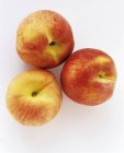 Три свіжих стиглих персика — стокове фото