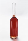 Vue rapprochée du vinaigre dans une bouteille en verre sur fond blanc — Photo de stock